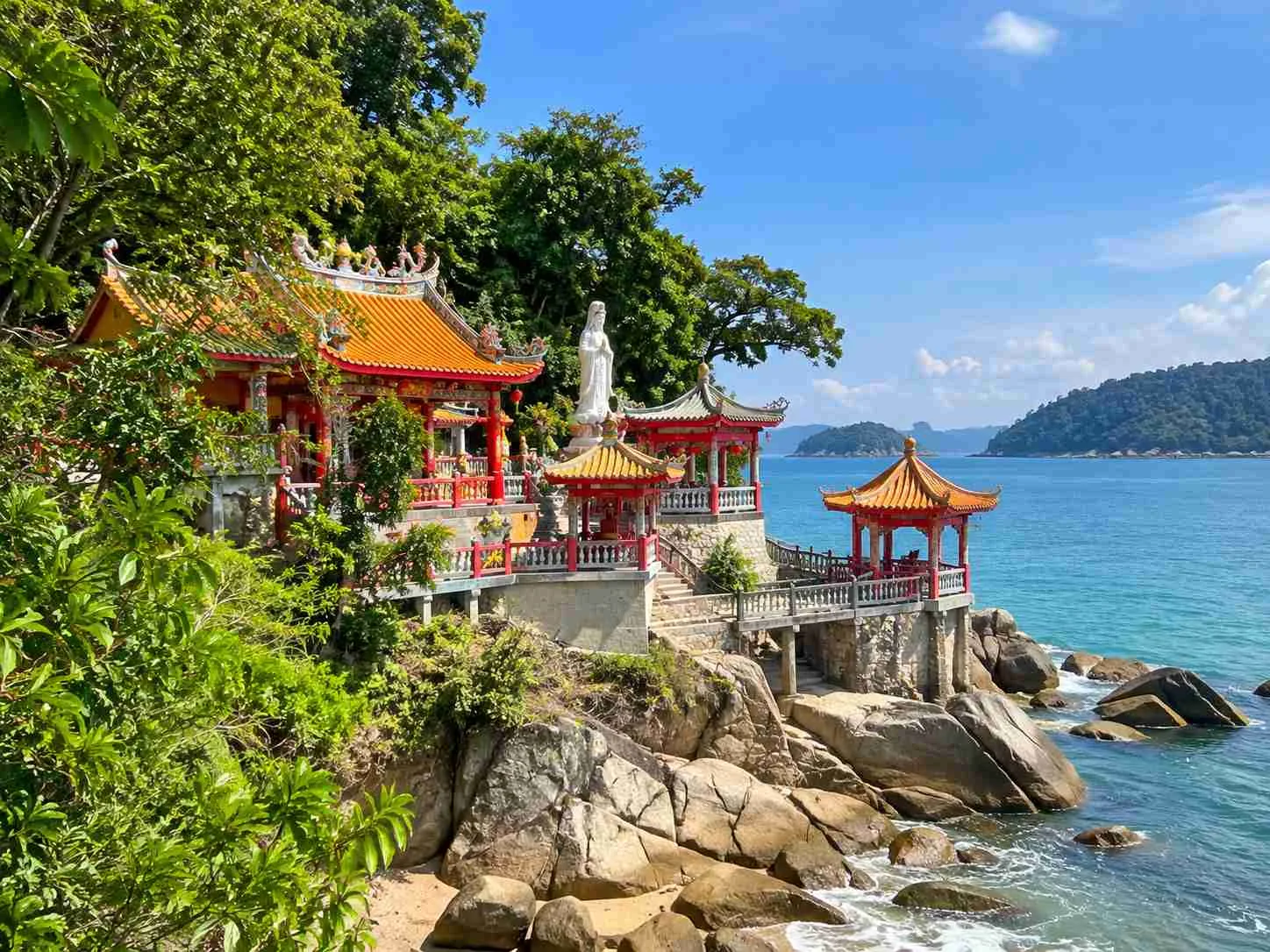 Lin Je Kong Temple beside Coral Beach on Pangkor Island with colourful Chinese statues, rocky surroundings and sea views
